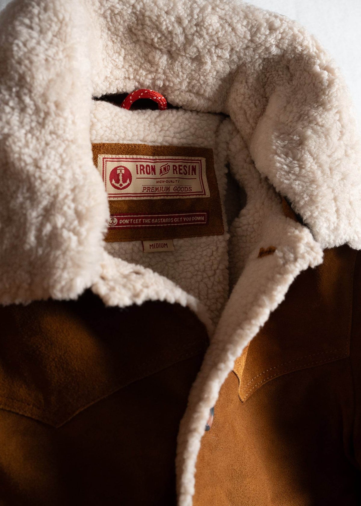 Brown jacket with soft, fluffy lining and an "Iron and Resin" label inside, showing premium quality and medium size.