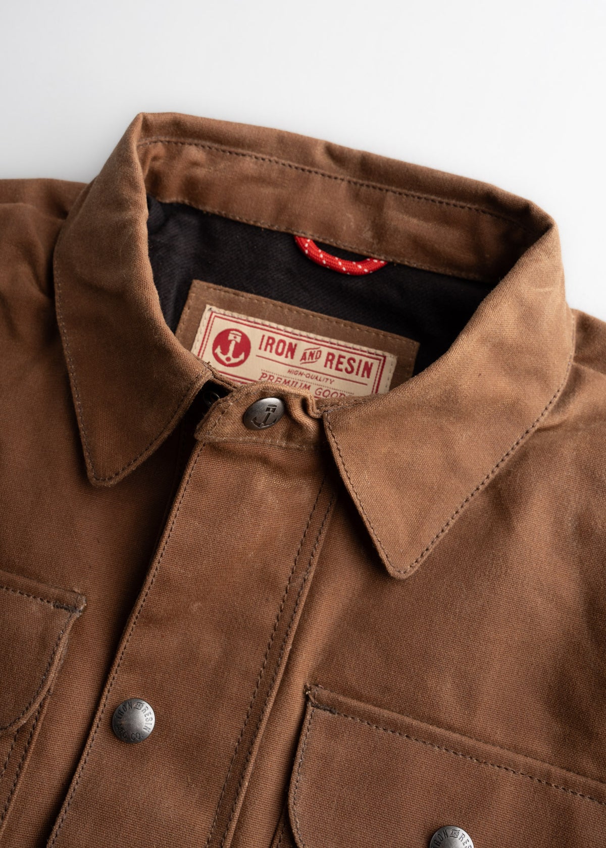 Brown Iron and Resin jacket with a collar and metal buttons, featuring a visible brand label inside.
