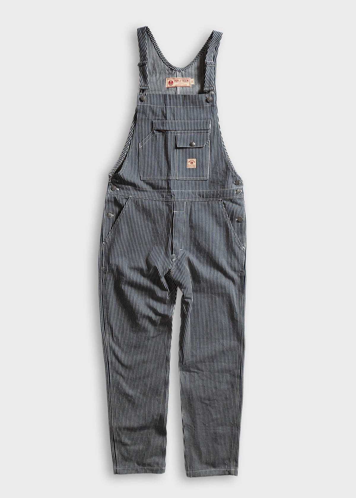 Blue and white striped overalls with front pockets and adjustable straps, displayed on a light background.