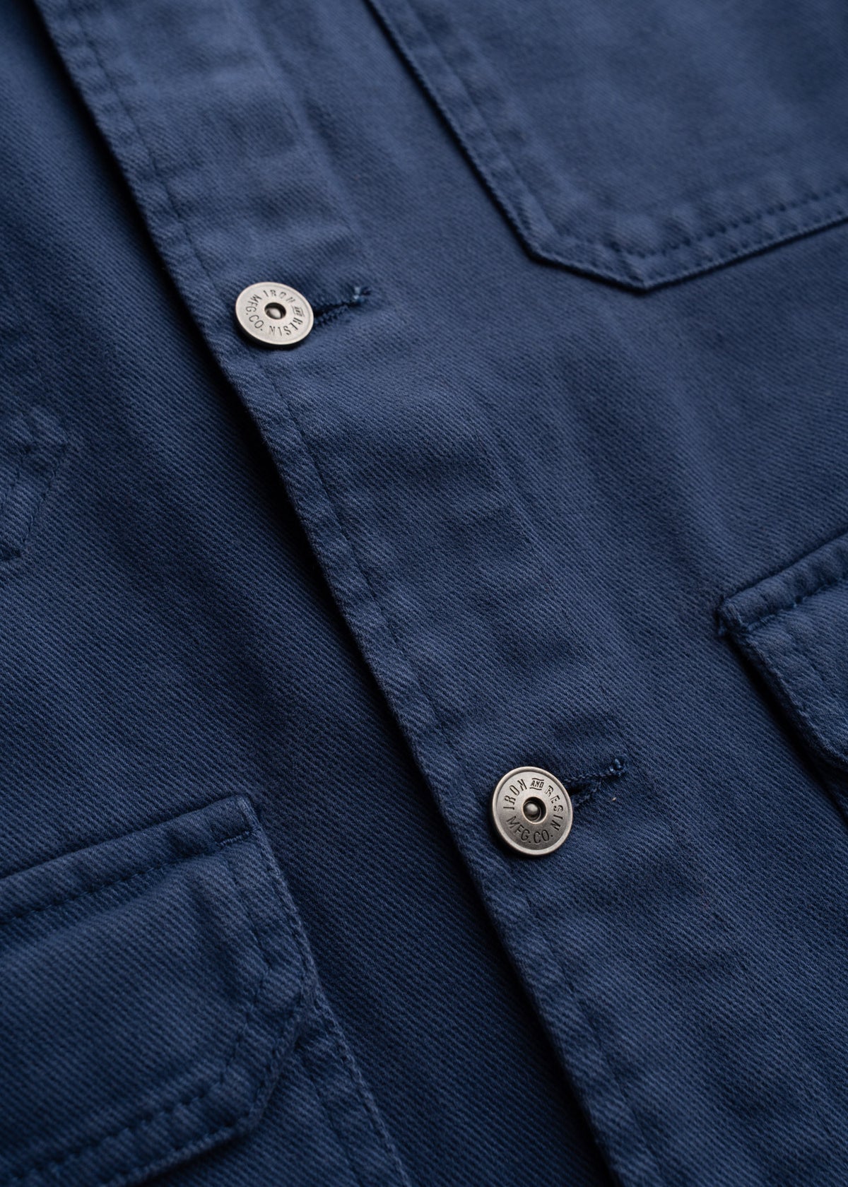 Close up of shank button hardware and engraved jean buttons on jacket, highlighting front closure and custom detailing