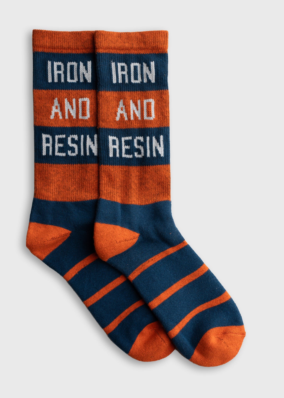 Orange and navy striped socks with "IRON AND RESIN" text, displayed on a white background.