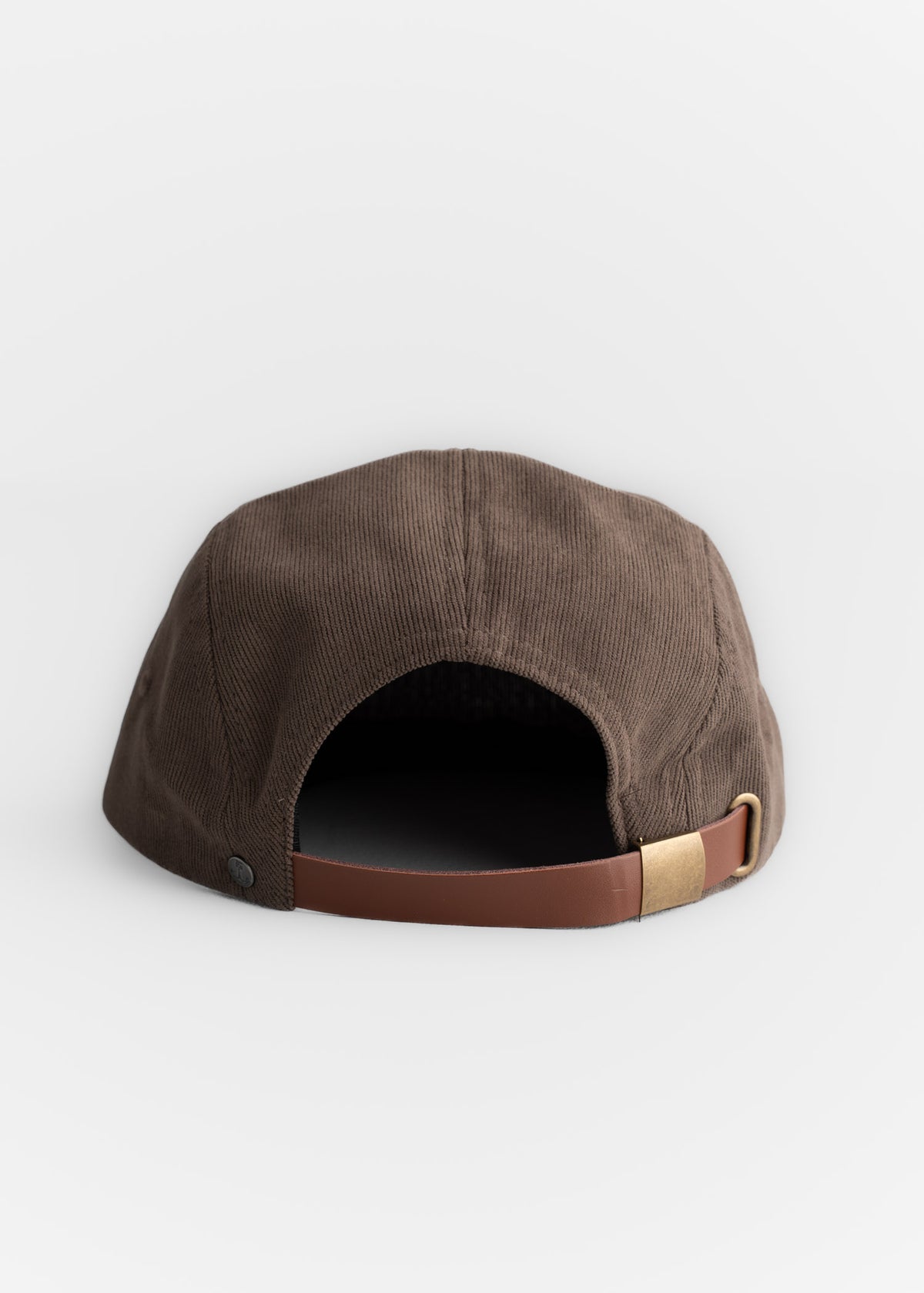 Brown corduroy cap with leather strap and brass buckle, viewed from the back against a plain white background.