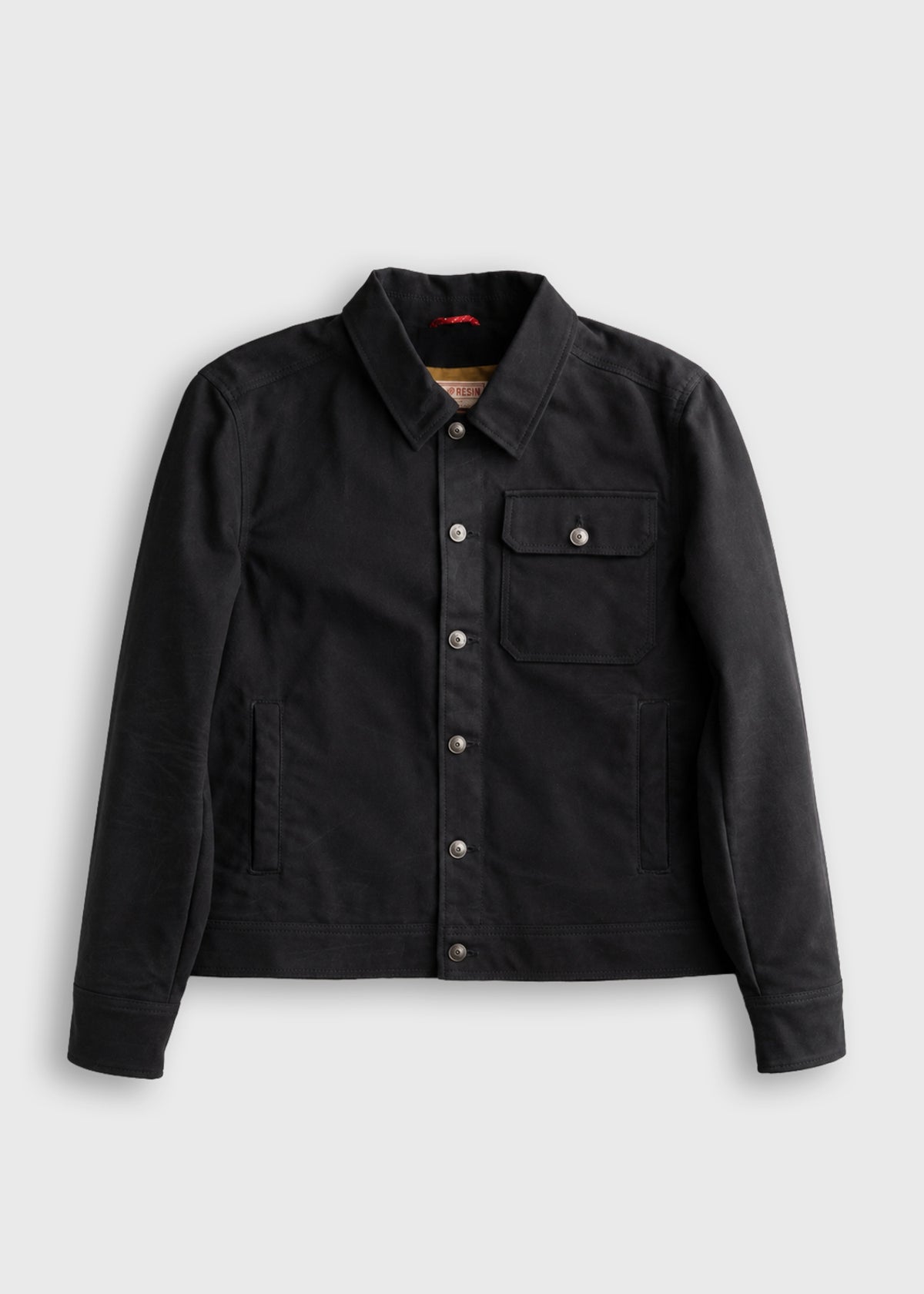 Black denim jacket with button closure, chest pocket, and collar, displayed on a plain white background.