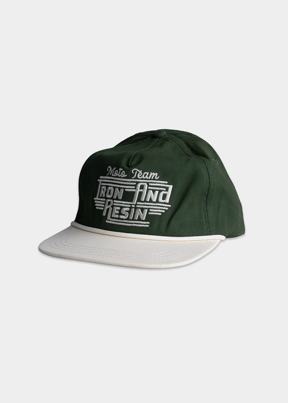 Green cap with "Moto Team Iron and Resin" embroidered in white, featuring a contrasting white brim on a plain background.