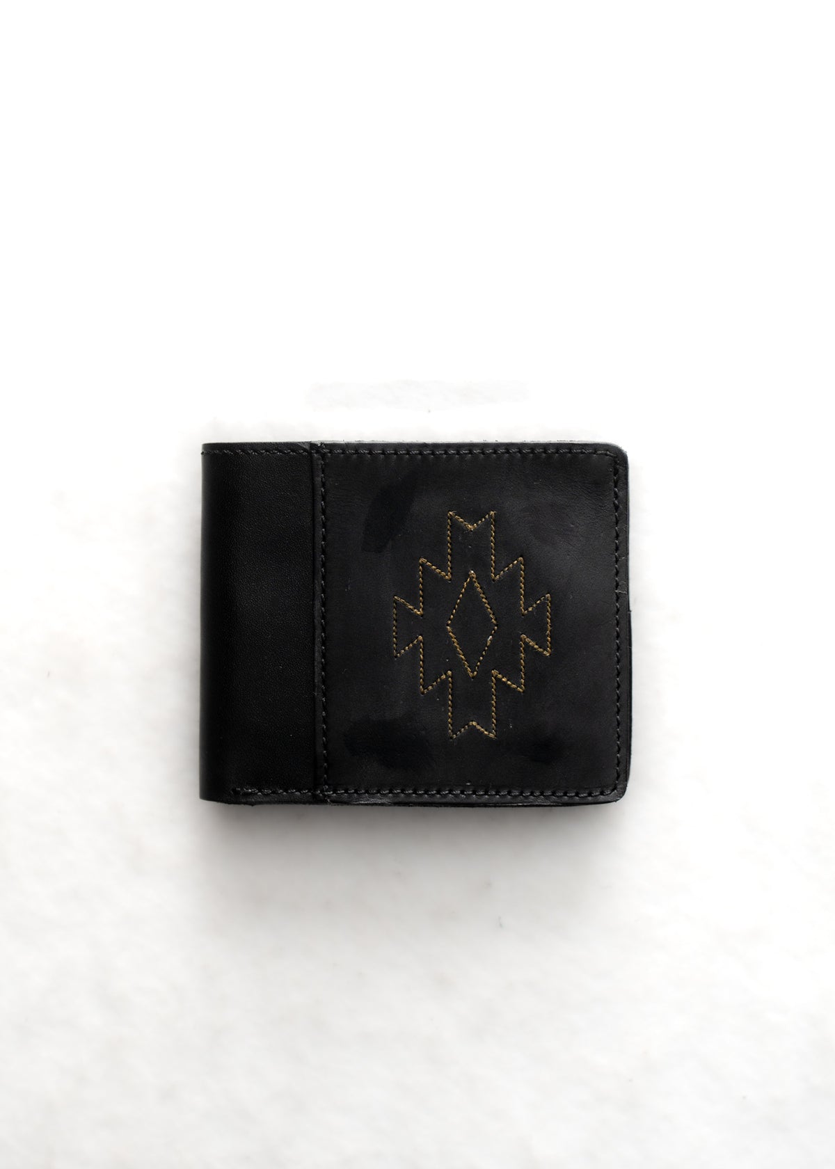 Black leather wallet with a geometric pattern in yellow stitching, set against a white background. Simple and elegant design.