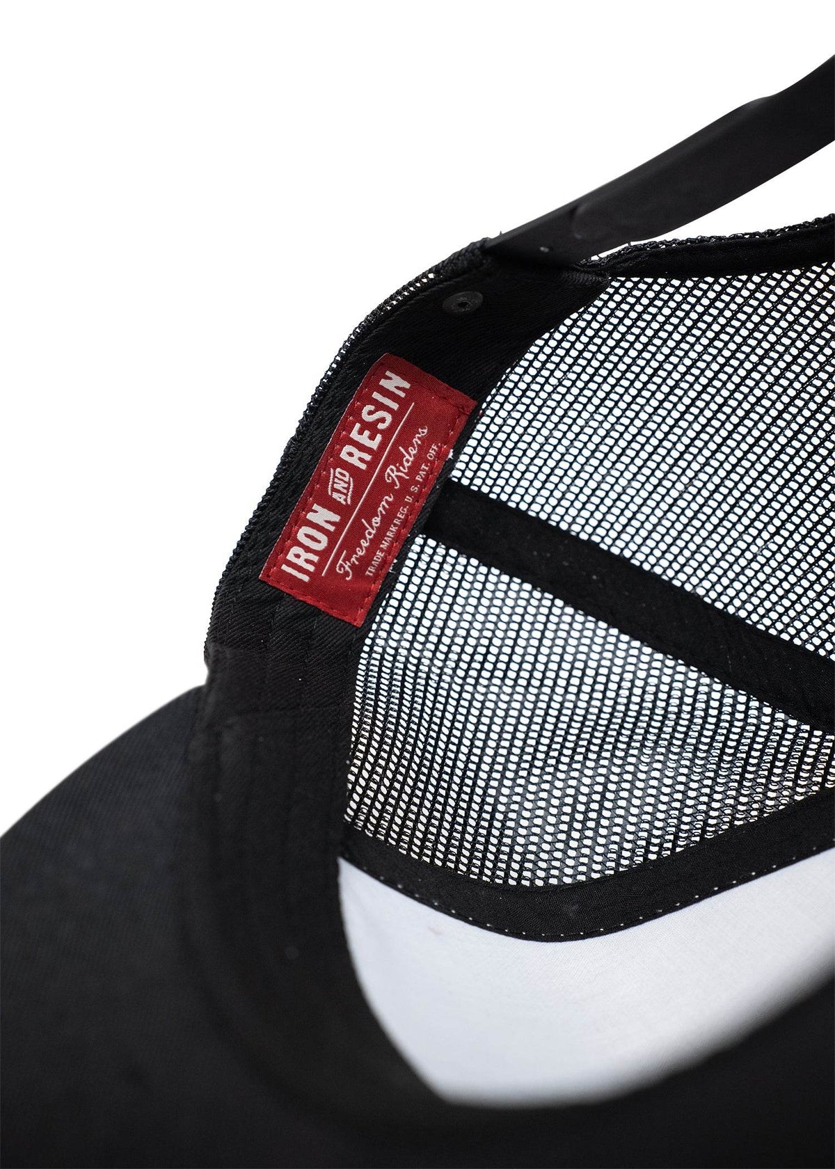 Close-up of a black mesh cap's interior, featuring a red "Iron and Resin" label with white text.
