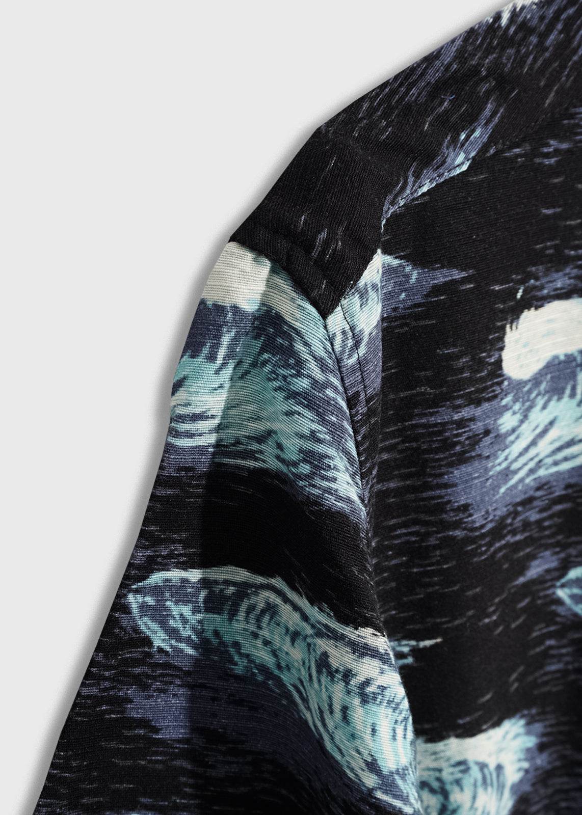 Close-up of a fabric with a swirling blue and black pattern, resembling abstract waves, highlighting texture and color contrast.