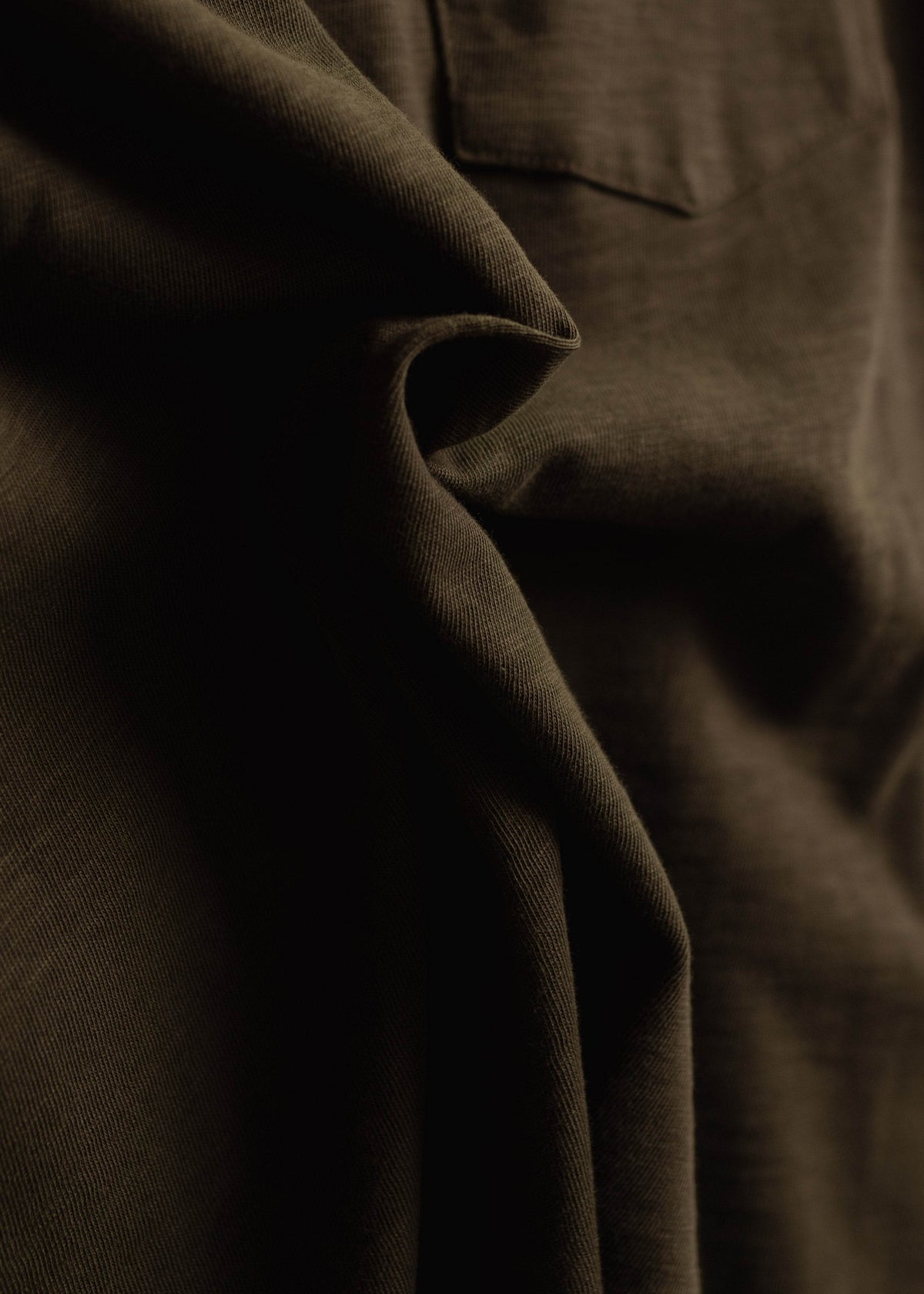 Close up of garment dyed cotton slub shirt showing detail and textured fabric with relaxed workwear finish