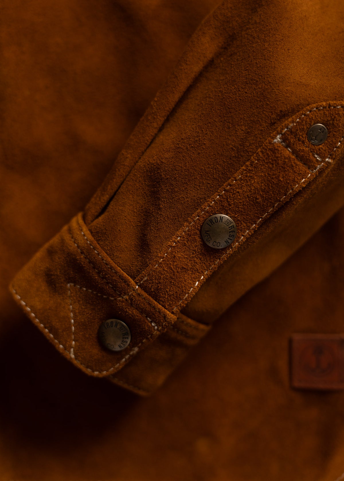 Rust-colored patterned shirt with geometric designs, buttoned front, and two chest pockets, labeled "Iron and Resin."