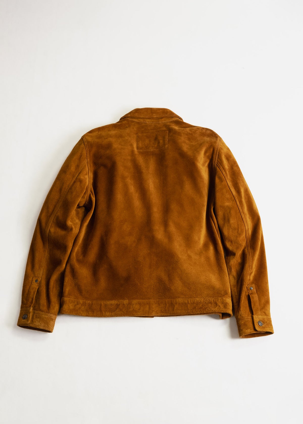 Brown suede jacket laid flat on a white surface, showcasing its back design with buttoned cuffs and a simple collar.