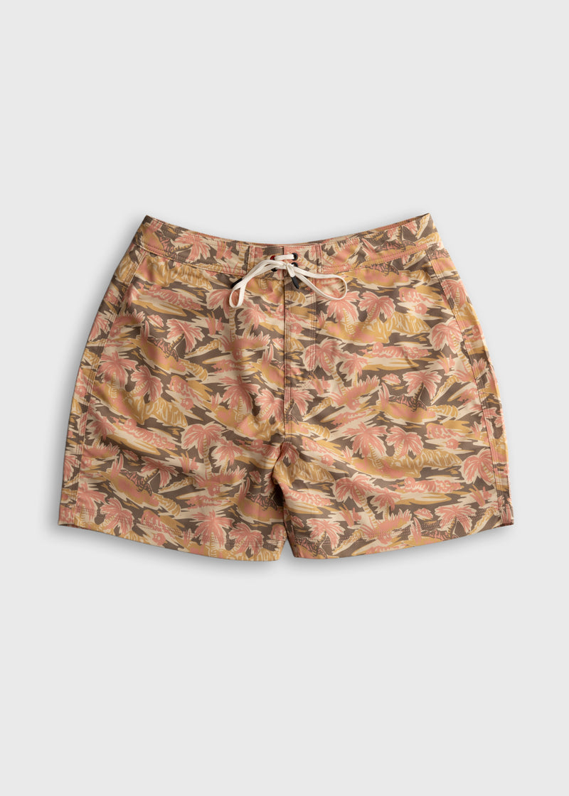 Floral swim trunks with pink and yellow palm leaves on a beige background, featuring a white drawstring on a flat surface.