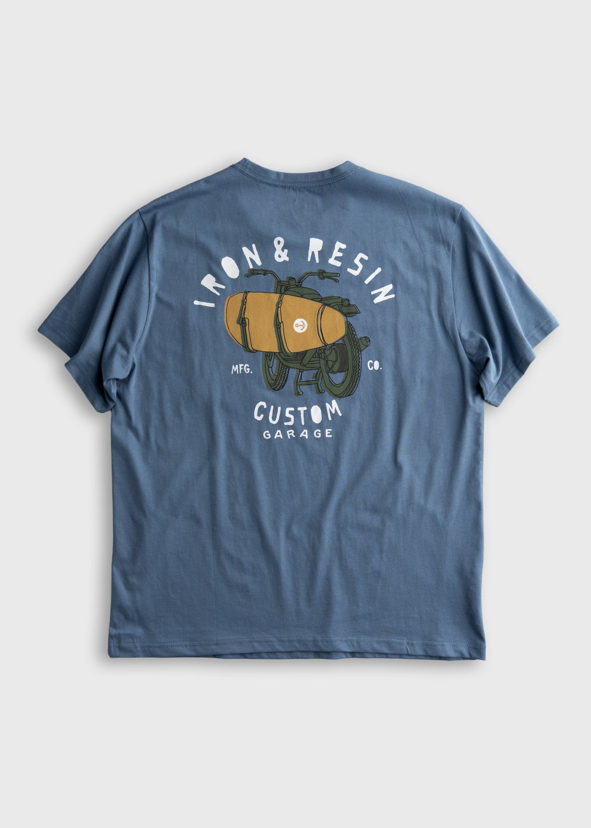 Blue T-shirt with "Iron & Resin Custom Garage" text and a motorcycle graphic on the back, featuring a surfboard design.