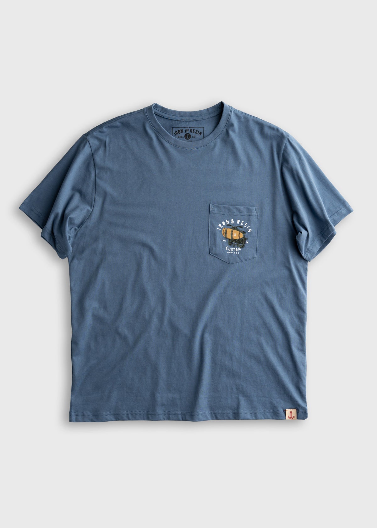 Blue t-shirt with a small pocket design featuring a motorcycle graphic. Simple and stylish casual wear on a plain background.