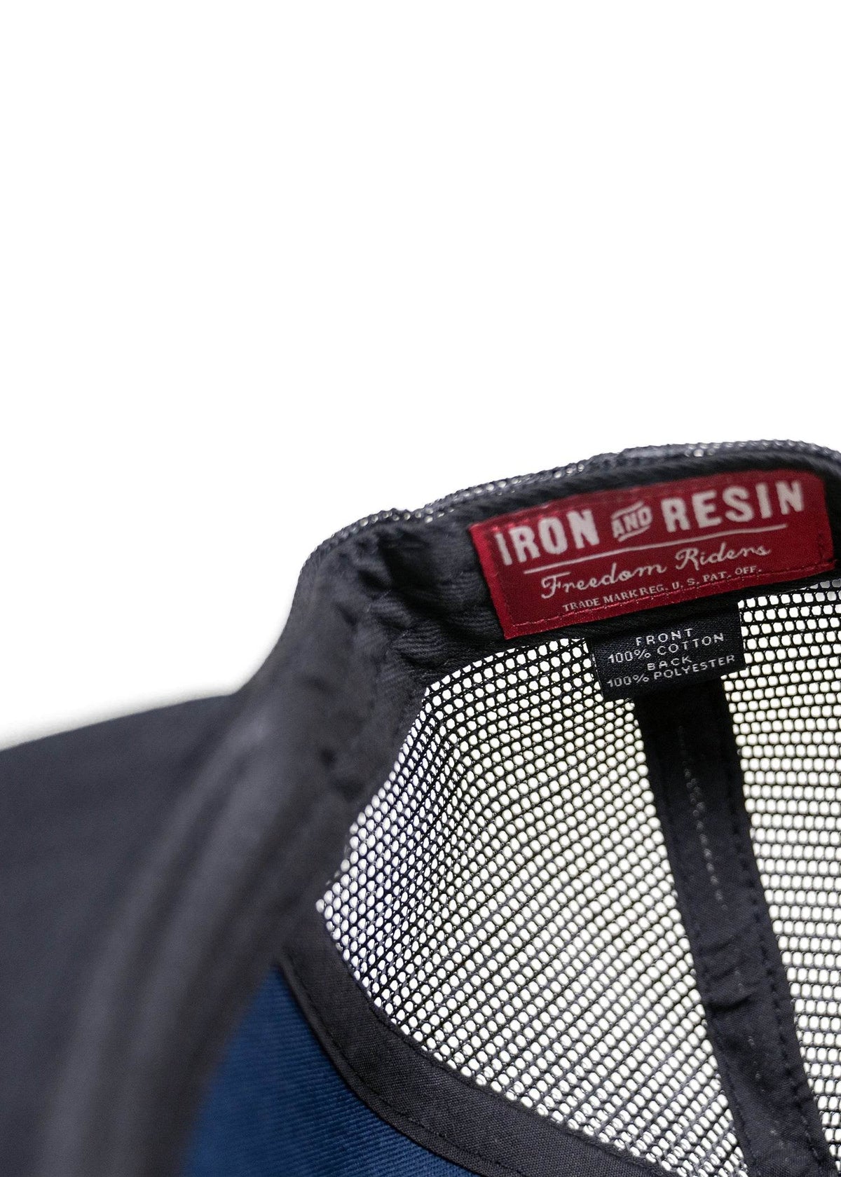 Close-up of a black mesh cap with "Iron and Resin" label, highlighting cotton and polyester materials.