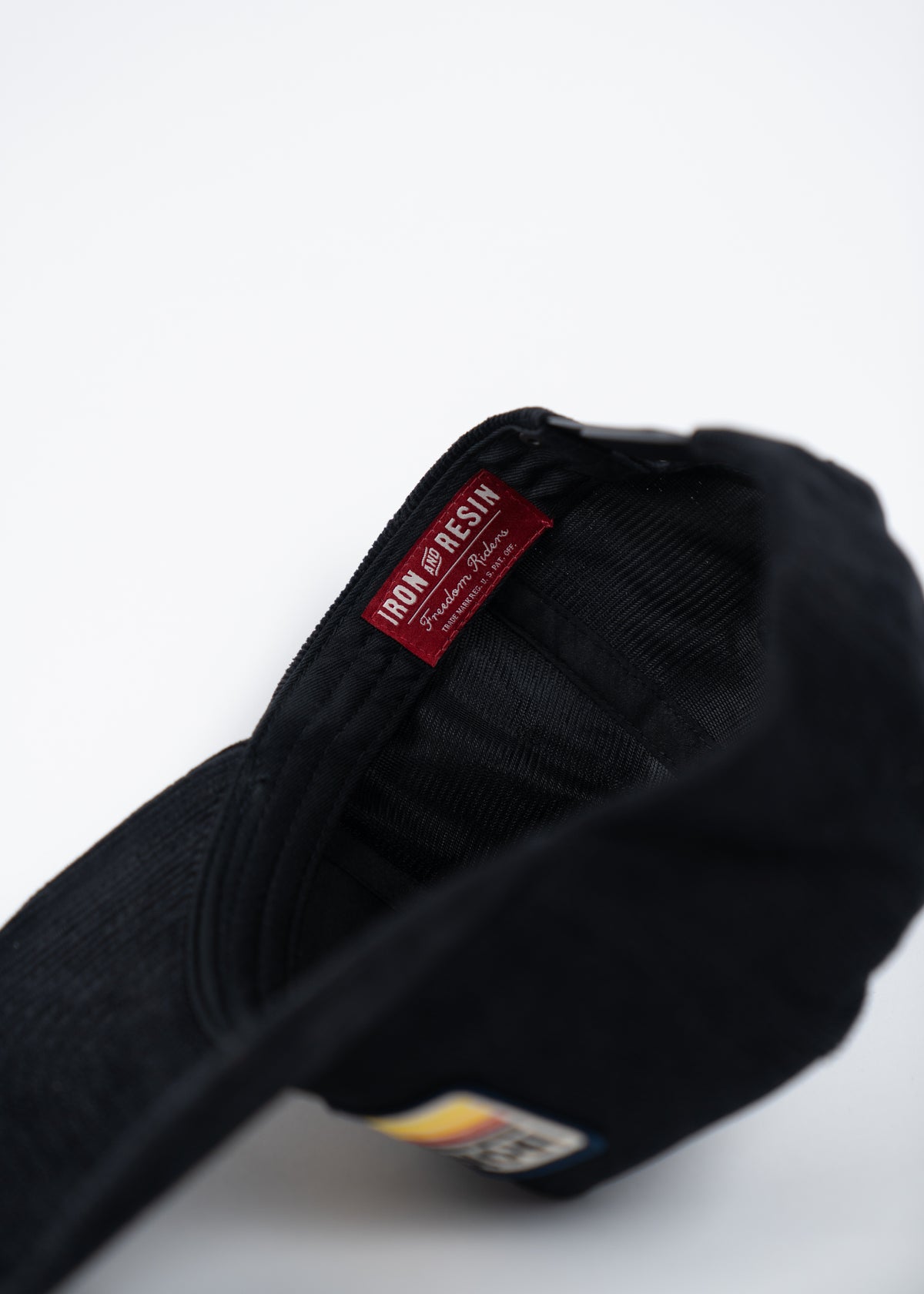 Black cap with a visible "Iron and Resin" label inside, showcasing brand detail against a white background.