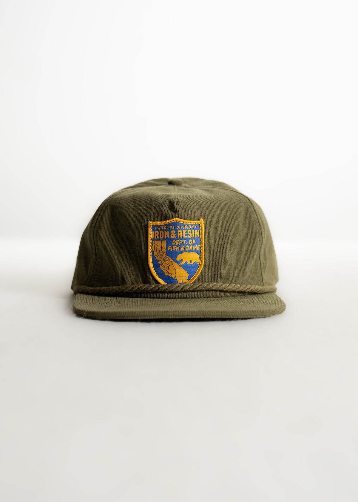 Olive green cap with "Iron & Resin Dept. of Fish & Game" patch featuring a bear and map, on a plain white background.