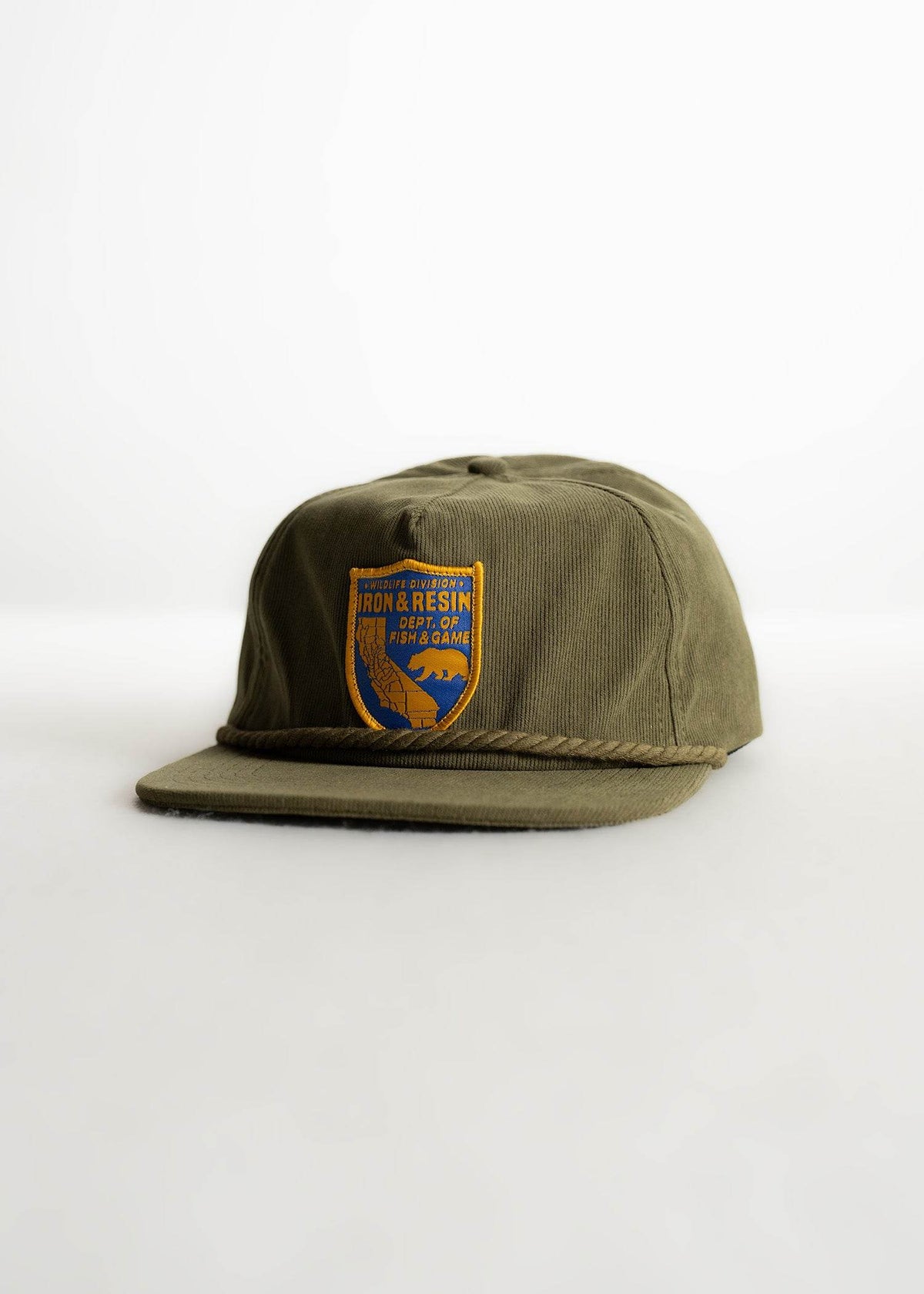 Olive green cap with "Iron & Resin Dept. of Fish & Game" patch, featuring a bear and map design, on a plain background.