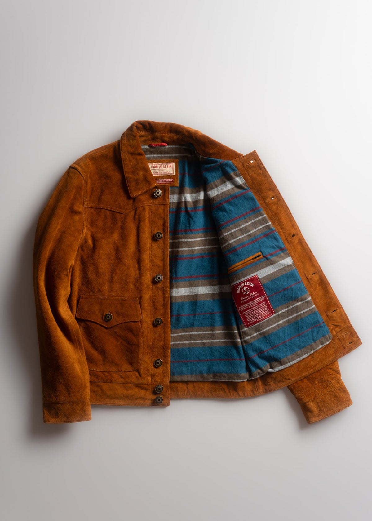 Brown suede jacket with blue striped lining, open to reveal a label inside. Buttoned front and pocket detail on the left side.