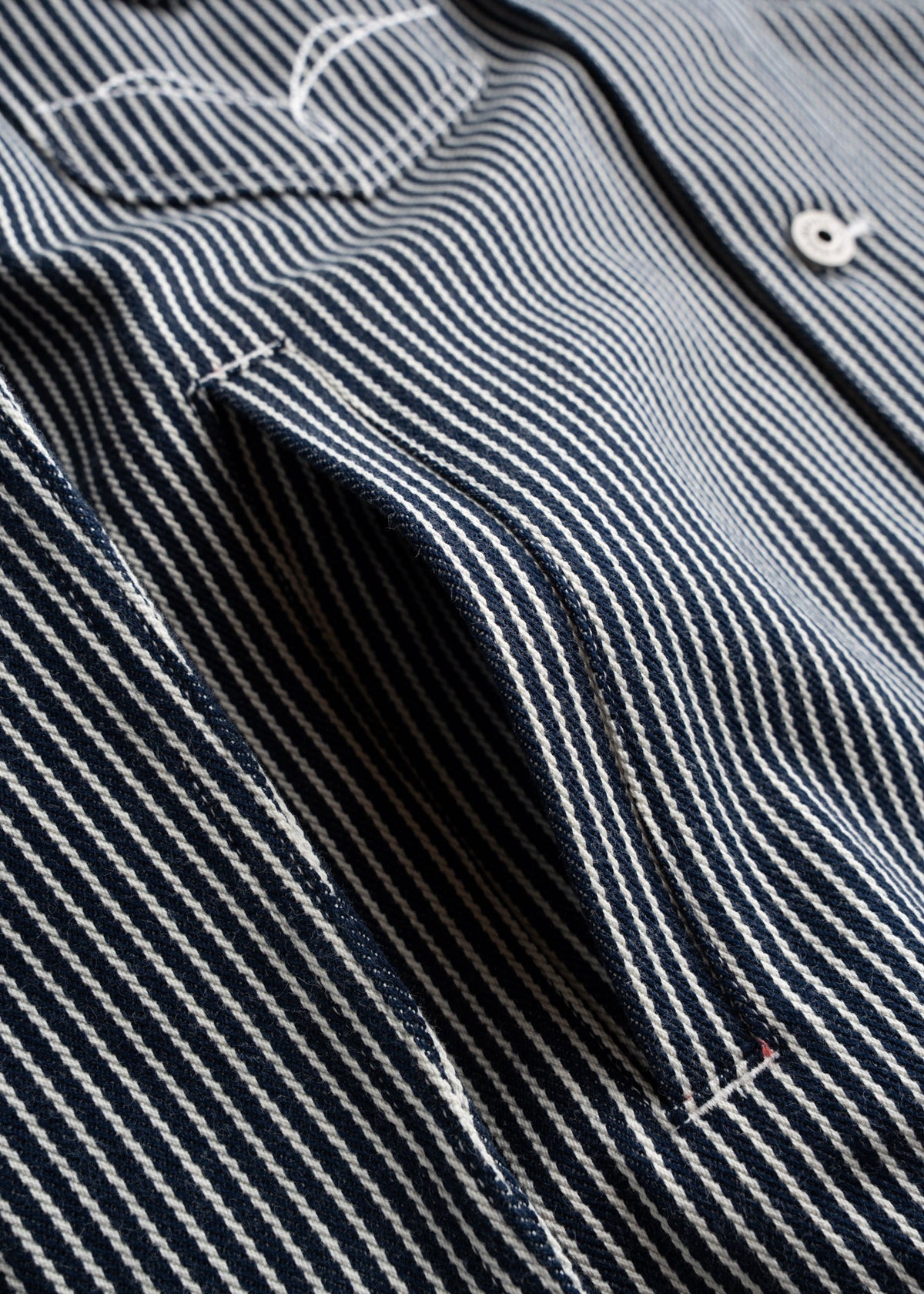 Close up of hand pockets, hickory striped denim fabric showing vertical stripe pattern and durable cotton weave
