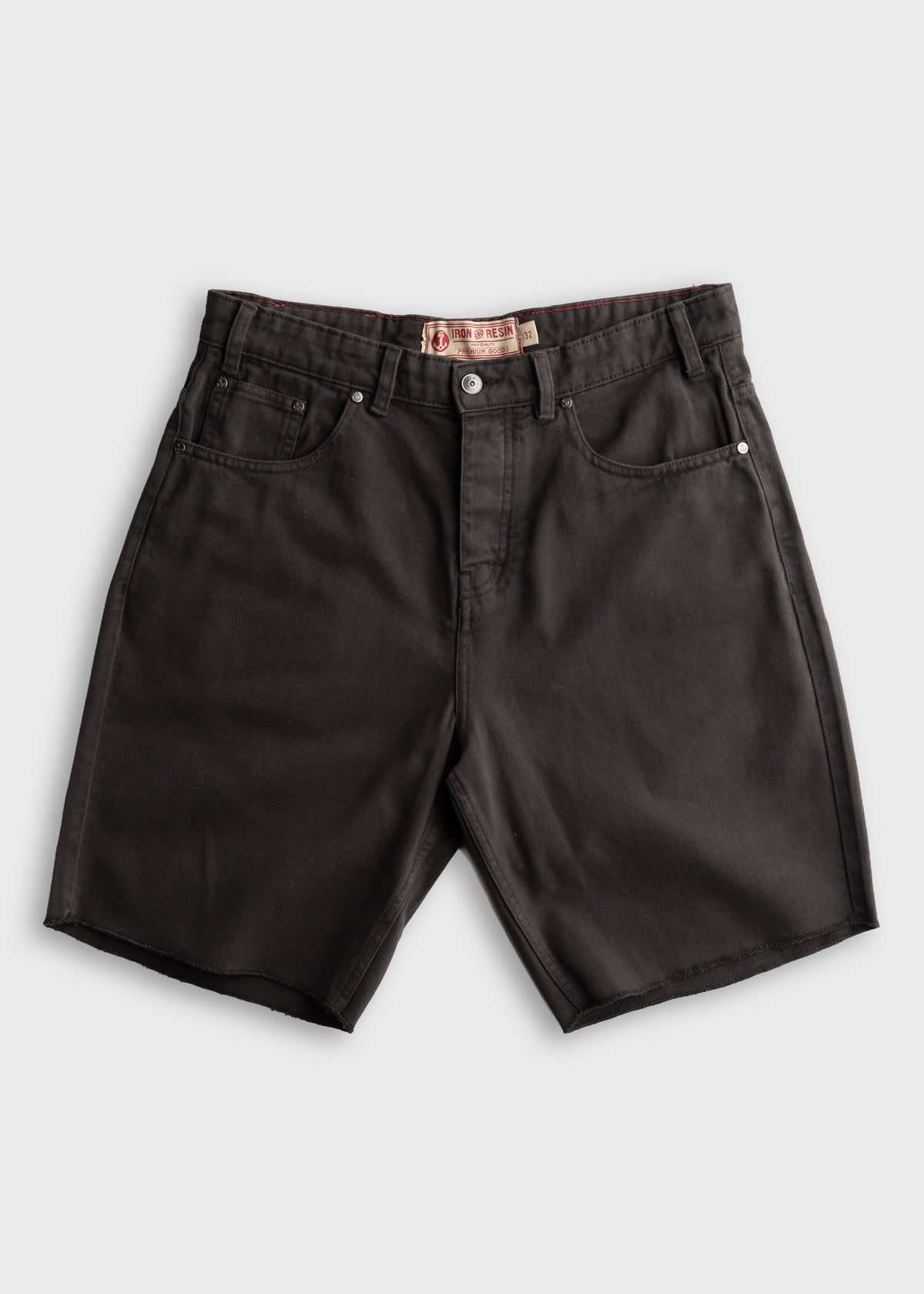 Black denim shorts with a button fly and five pockets, displayed on a plain background. The label reads "Iron & Resin.