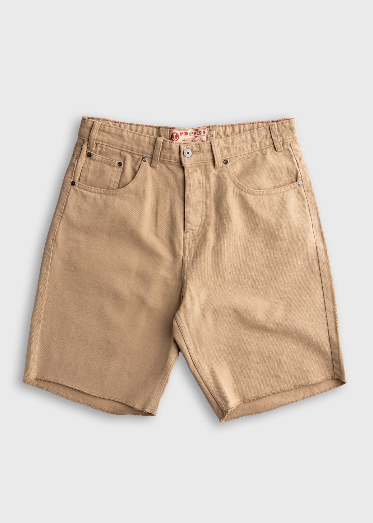 Tan denim shorts with frayed hems, front pockets, and a button closure, set against a plain white background.