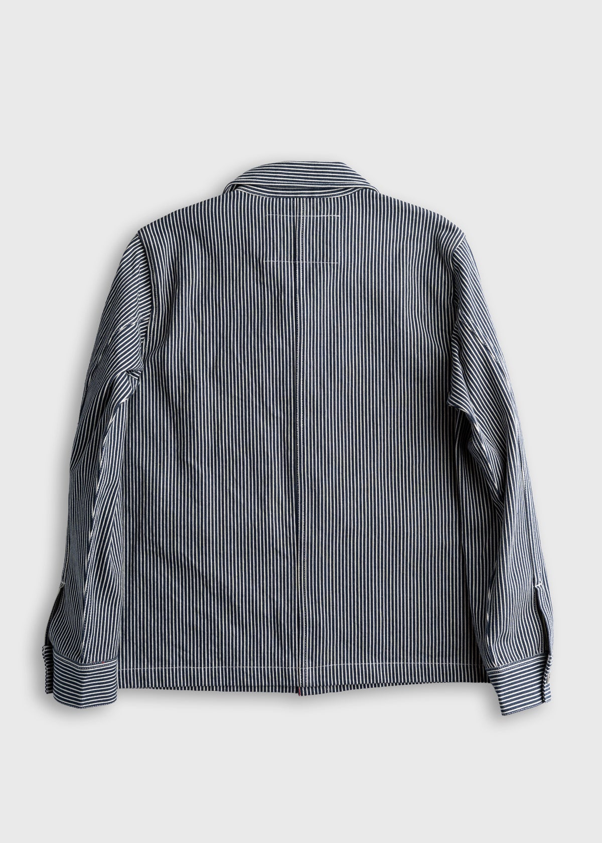 Back view of a blue and white striped jacket with long sleeves and a collar, displayed on a plain gray background.