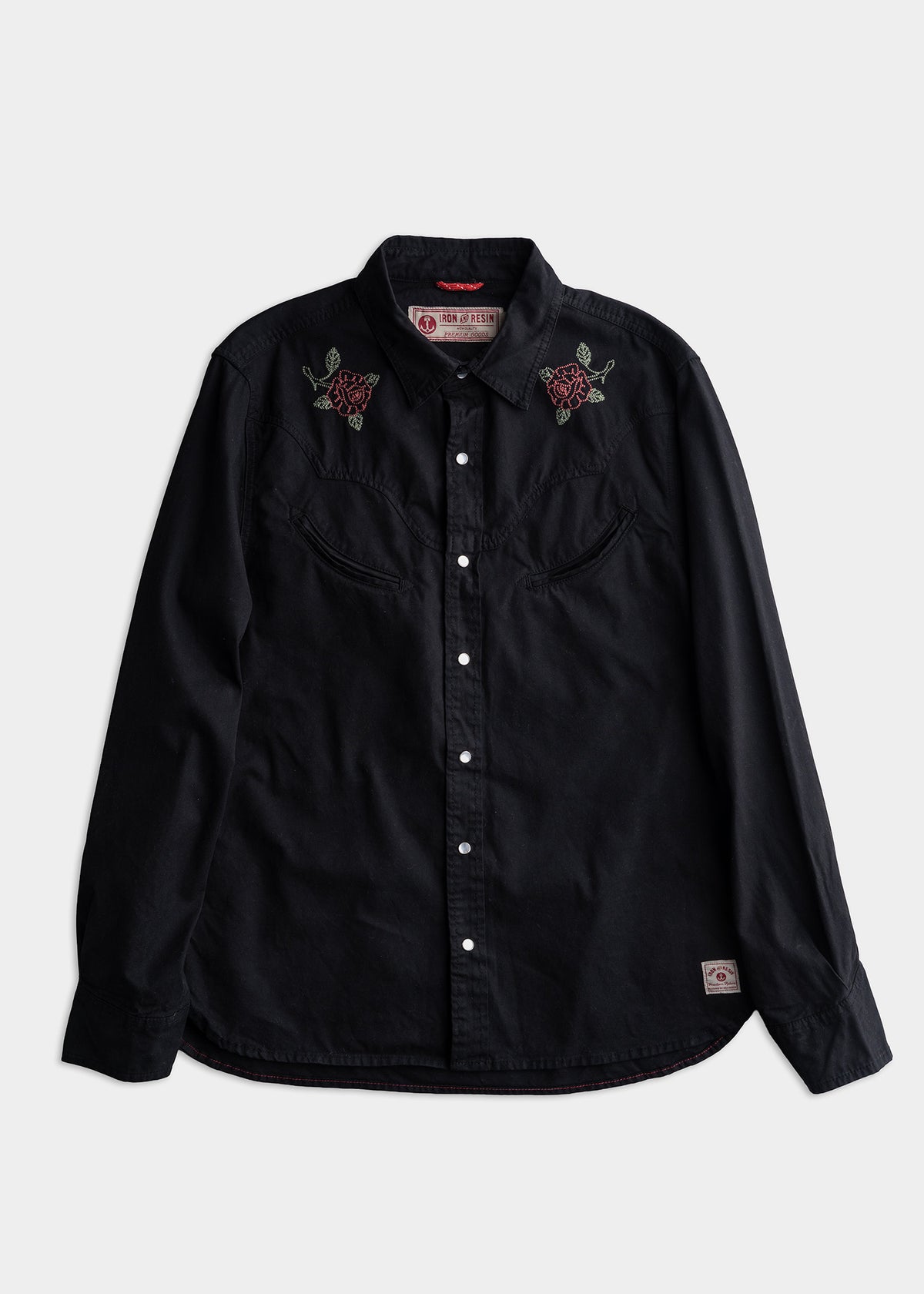 Black button-up shirt with red rose embroidery on shoulders, featuring a western style and a branded label on the bottom hem.