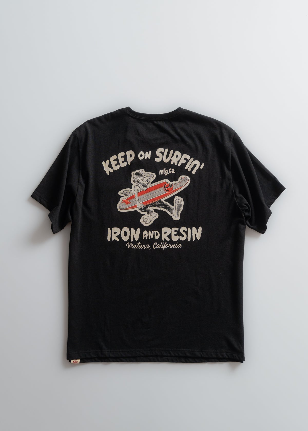 Black T-shirt with "Keep on Surfin'" and "Iron and Resin, Ventura, California" text, featuring a cartoon dog on a surfboard.