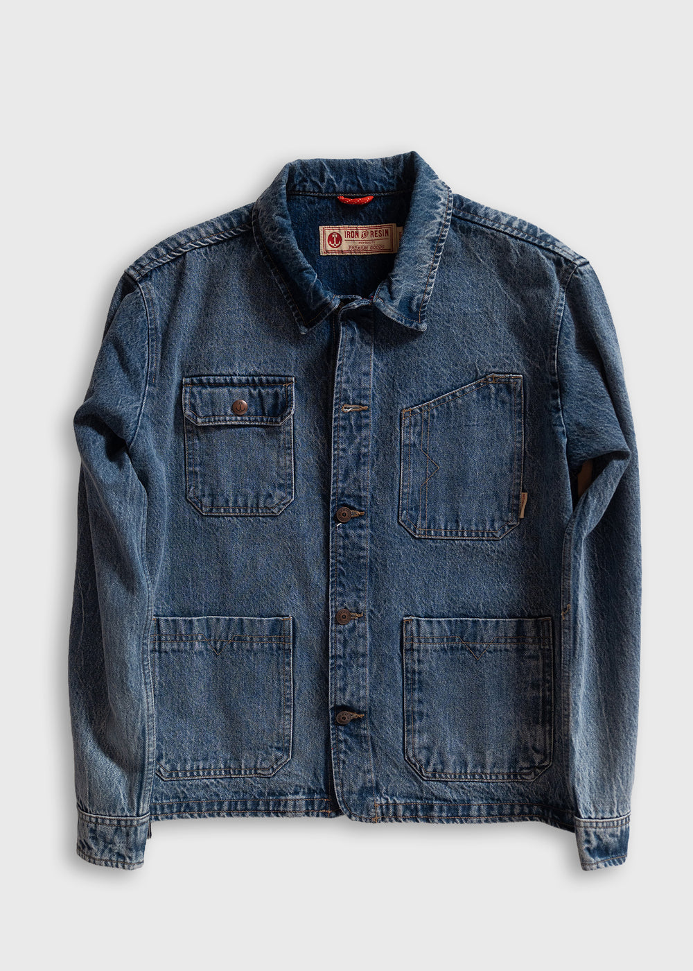 Blue denim jacket with button closure, four pockets, and a collar. The label reads "Iron & Resin" on a white background.