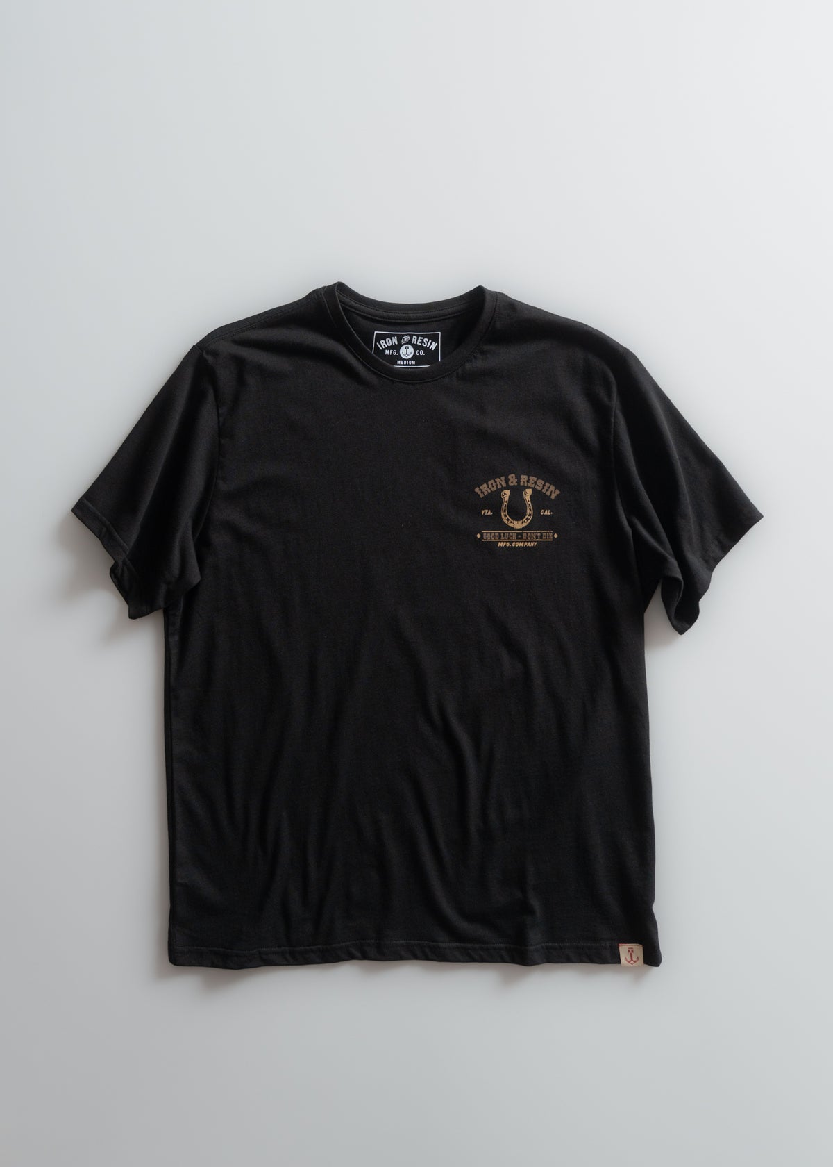 Black Iron & Resin T-shirt with small front logo design on a plain background, showcasing casual style and brand identity.