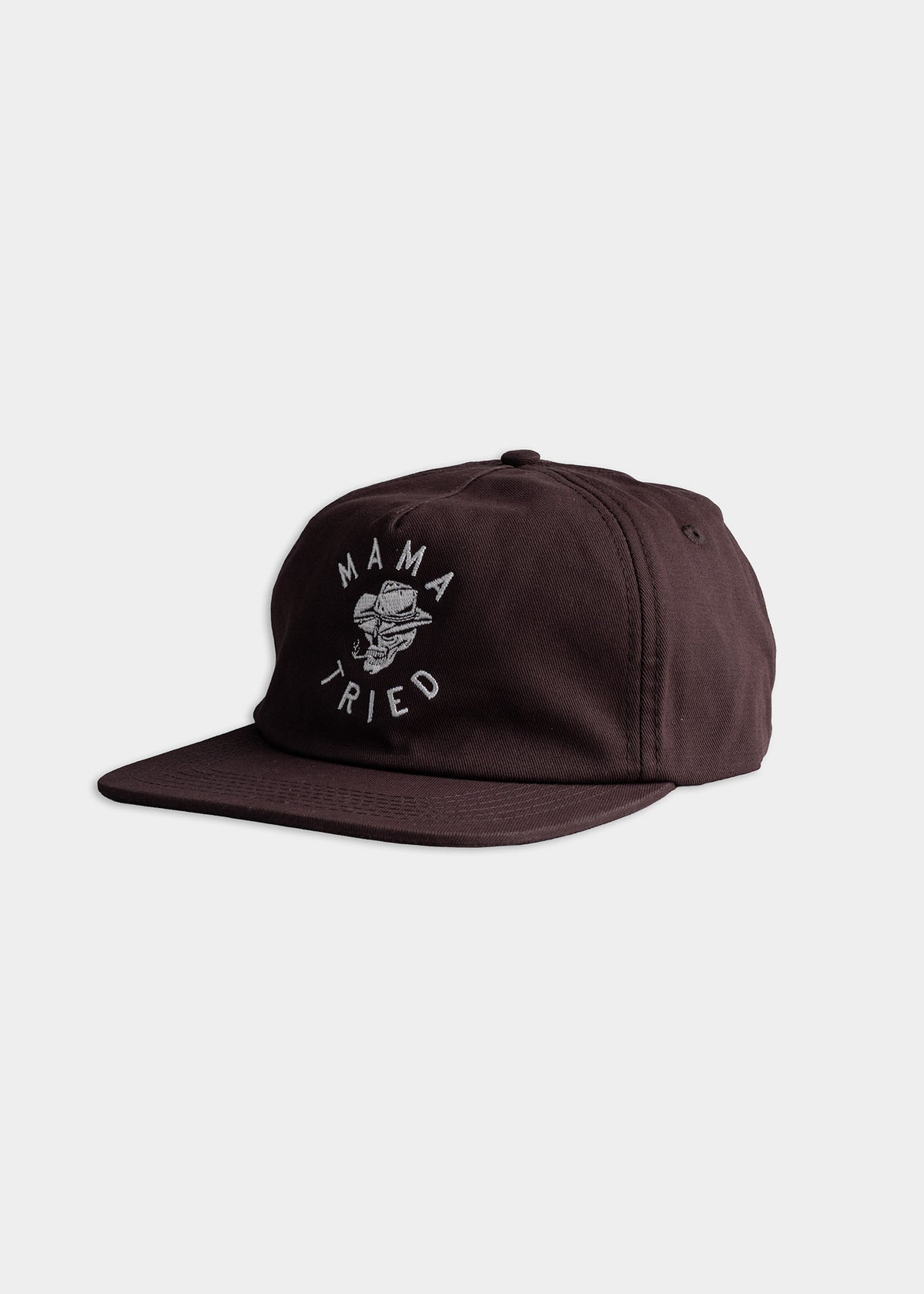 Brown cap with "Mama Tried" text and a skull graphic on the front, set against a plain white background.