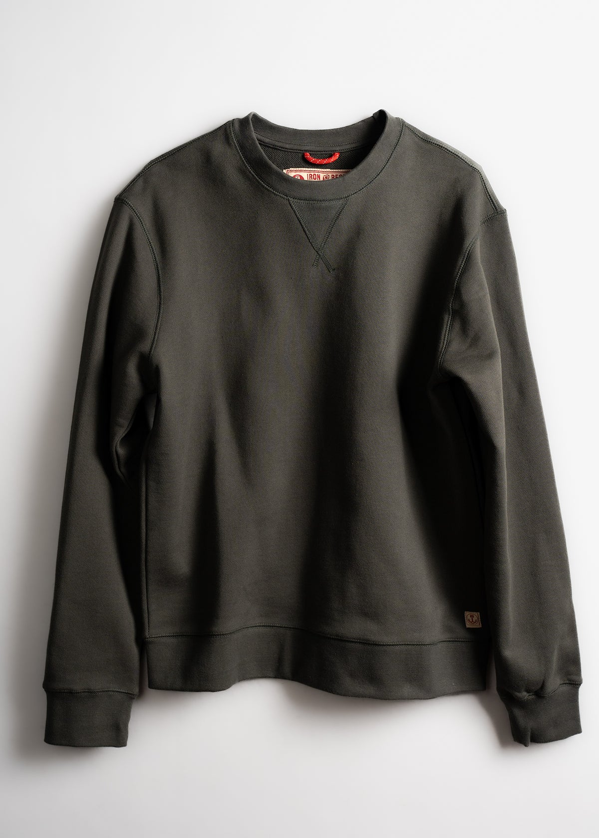 Dark green crewneck sweatshirt with ribbed cuffs and hem, displayed on a white background. Simple, casual design.