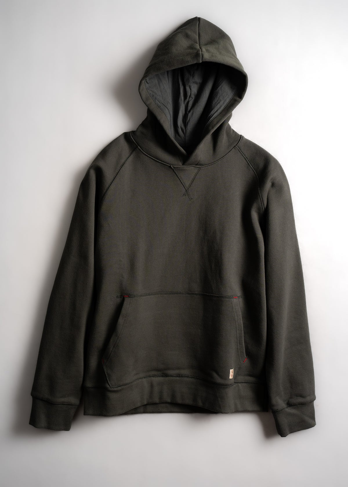 A dark green hoodie with a front pocket and hood, displayed on a plain white background, highlighting its casual style.