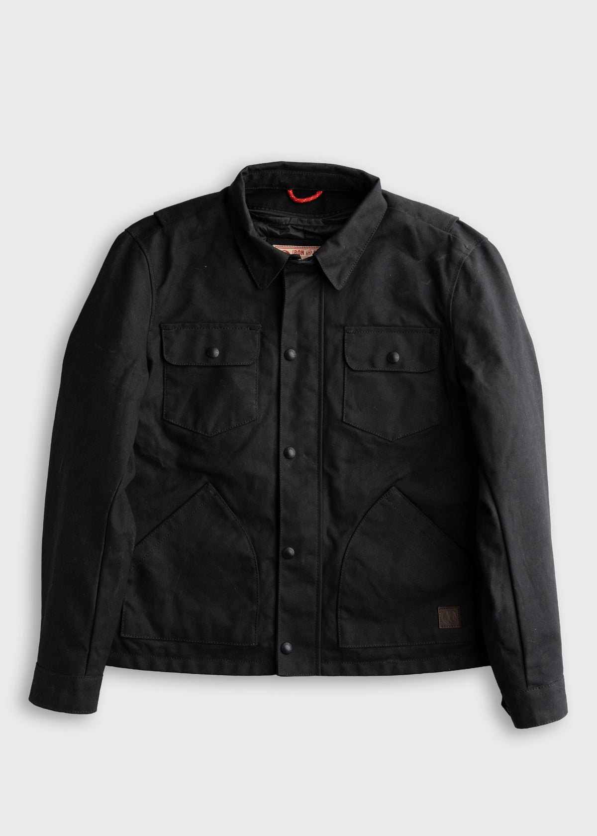 Black jacket with buttoned front, two chest pockets, and a collar, displayed against a plain background.