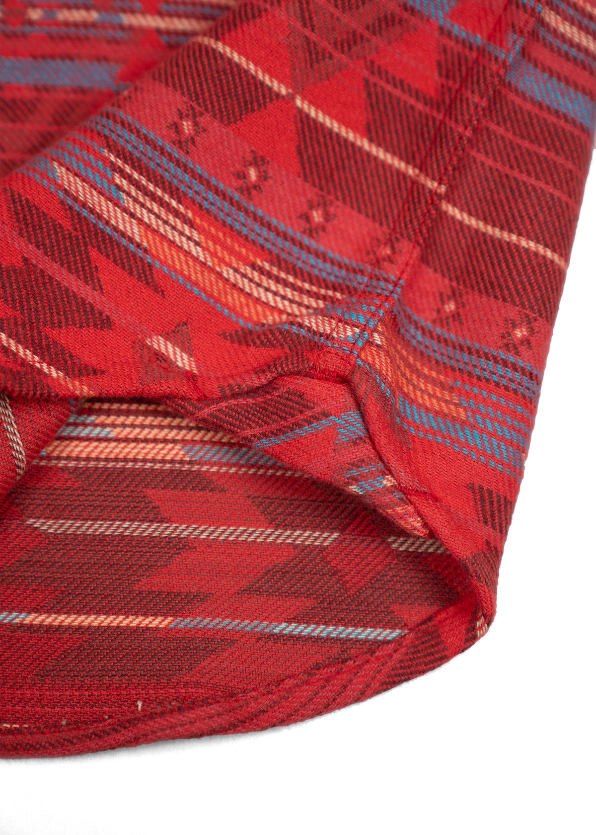 Close-up of a red fabric with a geometric pattern featuring blue and orange stripes, showcasing intricate textile design.