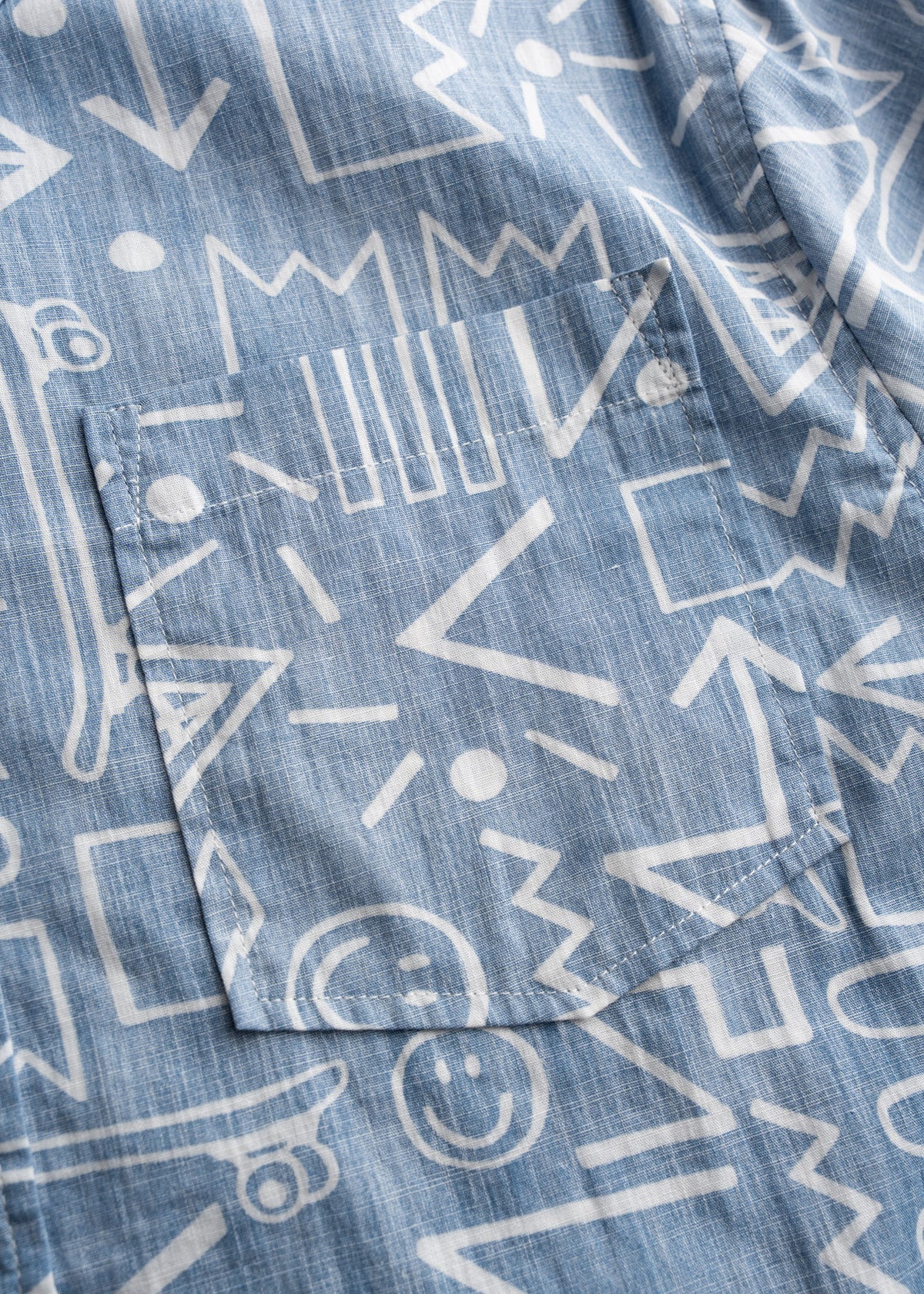 Close up of chest pocket, and poplin cotton fabric showing smooth lightweight weave and breathable texture