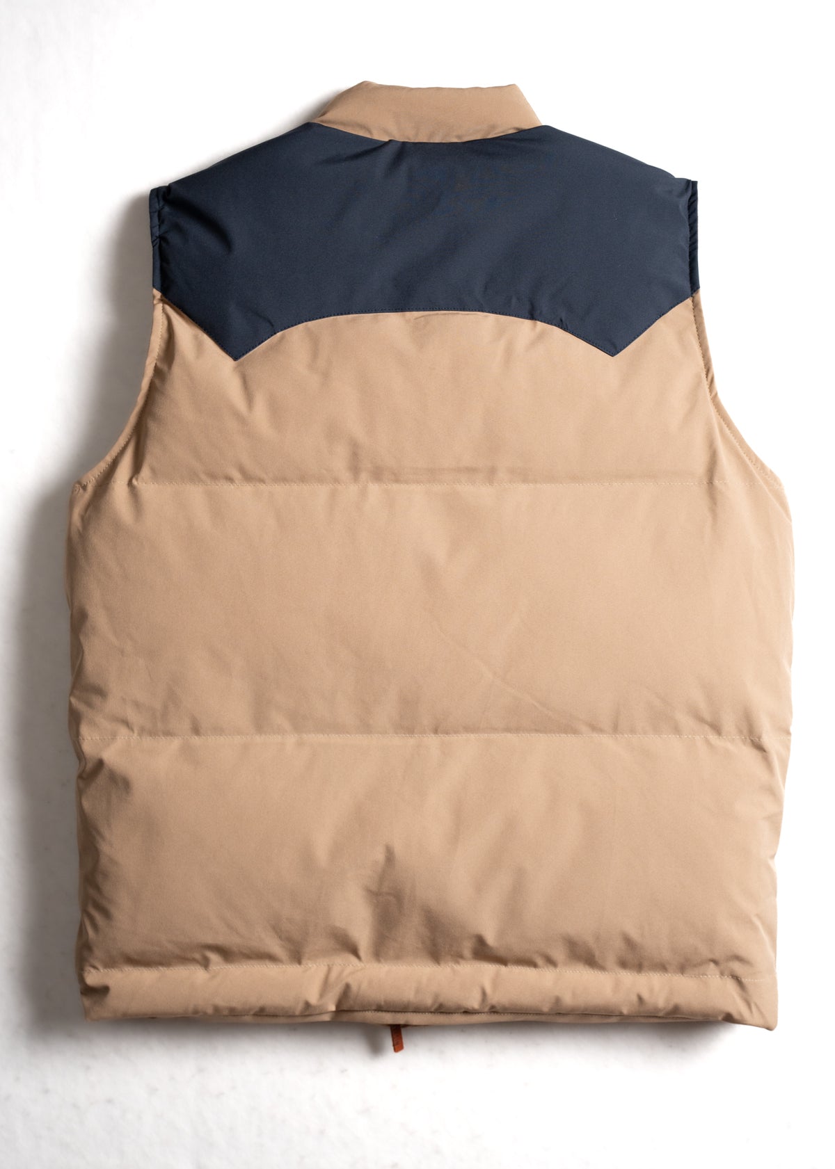 Tan puffer vest with a dark blue yoke, displayed on a white background, showcasing its back design.