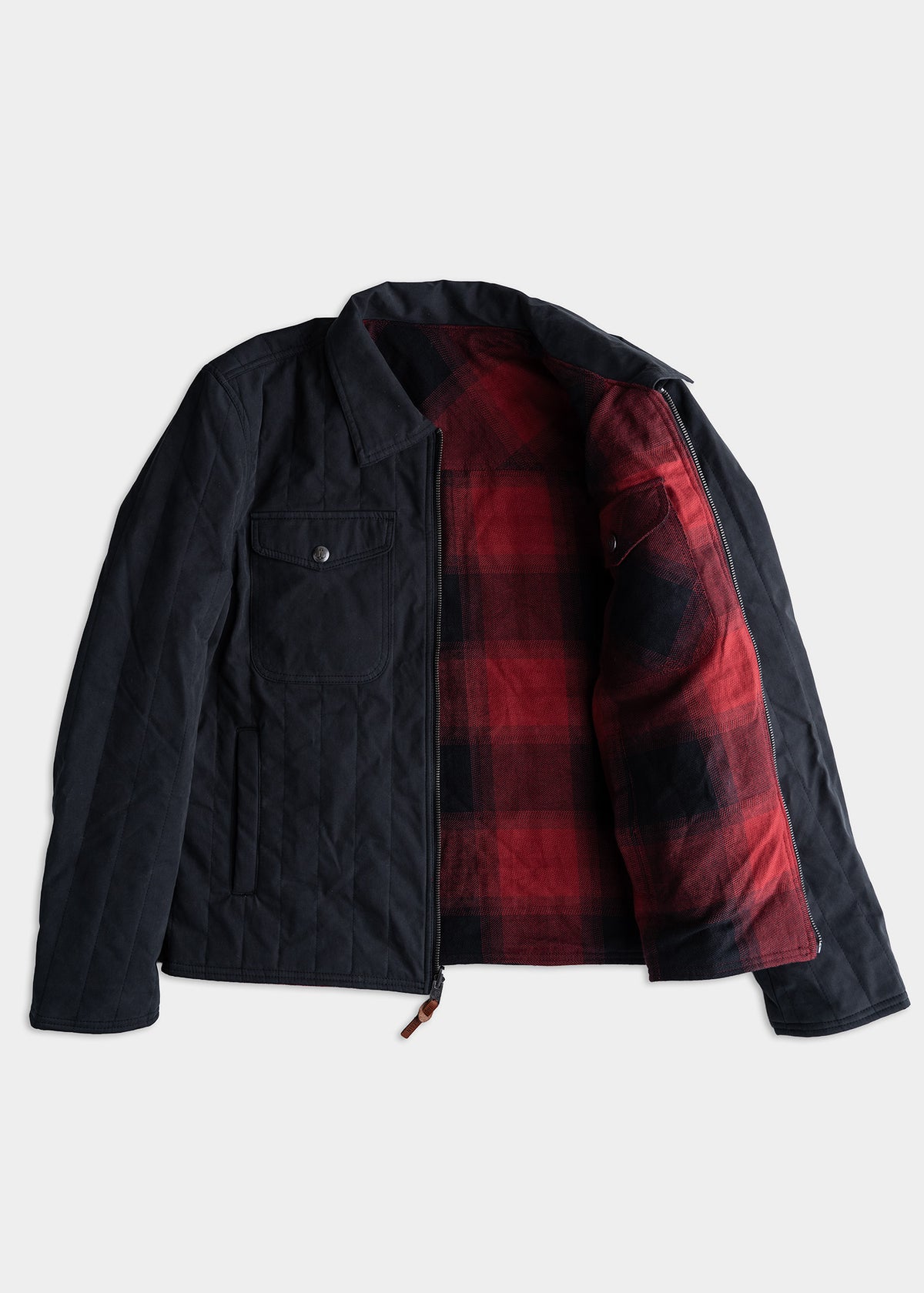 Black jacket with red plaid lining, open to show interior. Features a chest pocket and zipper closure, laid on a white background.