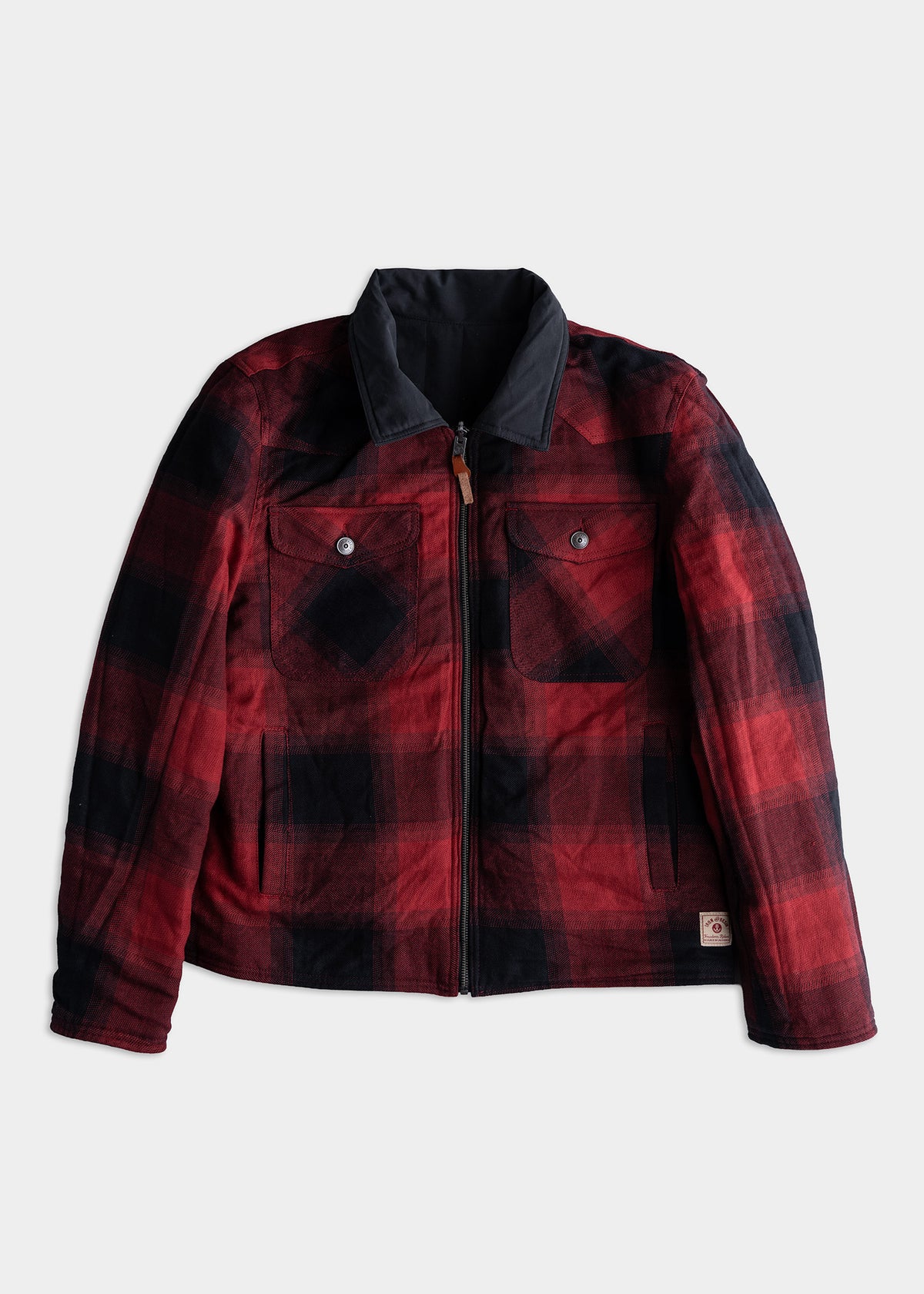 Red and black plaid jacket with a black collar, front zipper, and buttoned chest pockets, displayed on a plain white background.