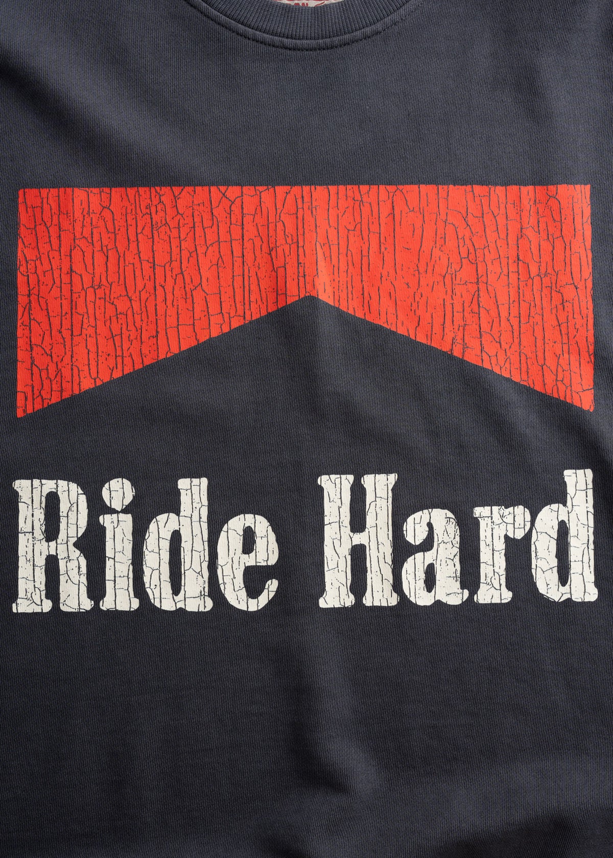 Black shirt with a cracked red arrow design above bold white text reading "Ride Hard."