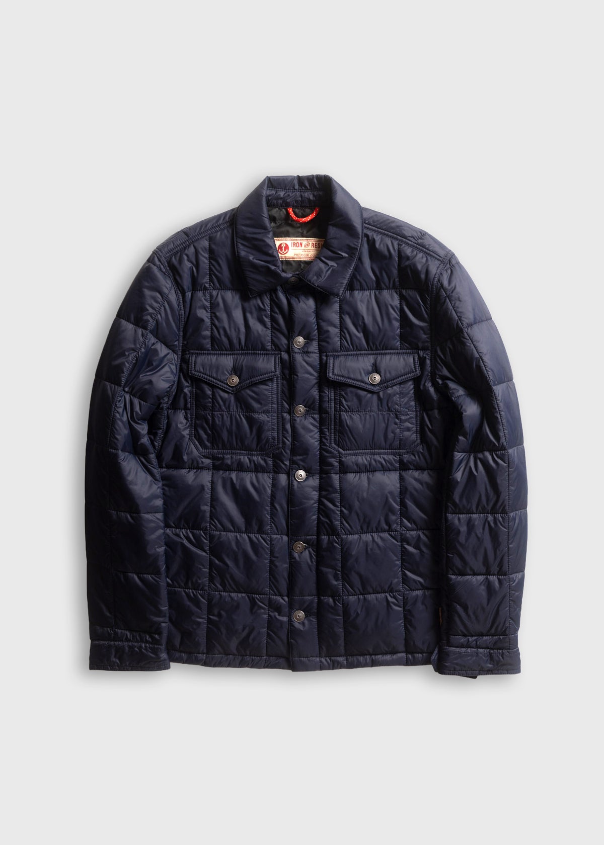 Navy quilted jacket with button closure, two chest pockets, and a collar, displayed on a plain white background.