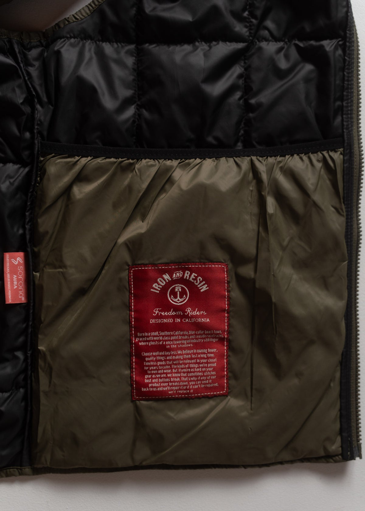 Jacket interior with a red "Iron and Resin" label, highlighting "Freedom Riders" and "Designed in California" text.