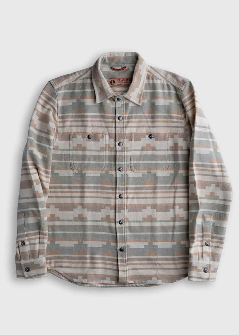 Patterned flannel shirt with earthy tones, buttoned front, and two chest pockets, laid flat on a white background.
