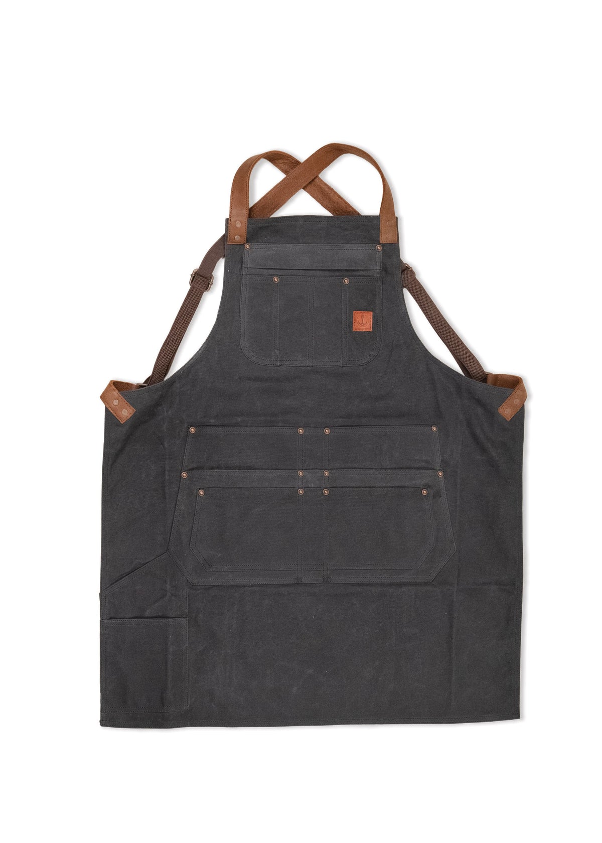 Dark canvas apron with brown leather straps and multiple pockets, designed for durability and functionality in work settings.