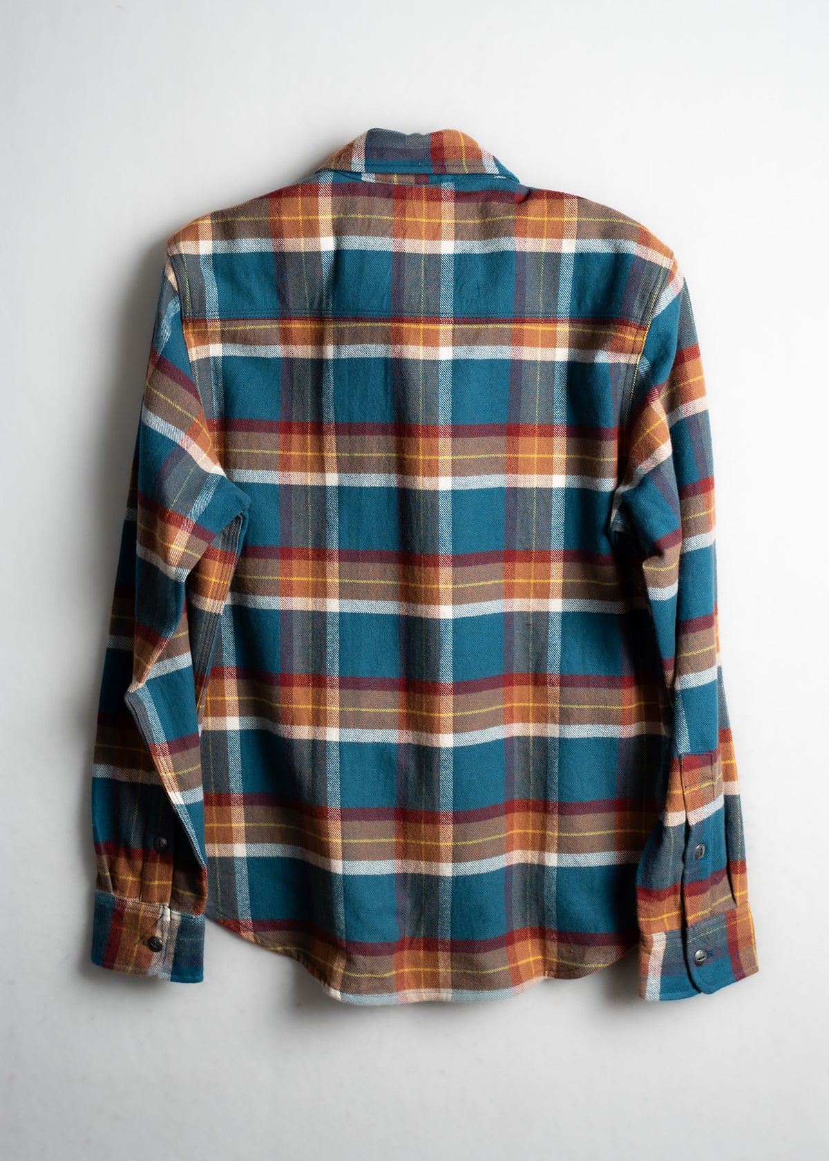 A blue, red, and yellow plaid flannel shirt displayed on a white background, showcasing its back and long sleeves.