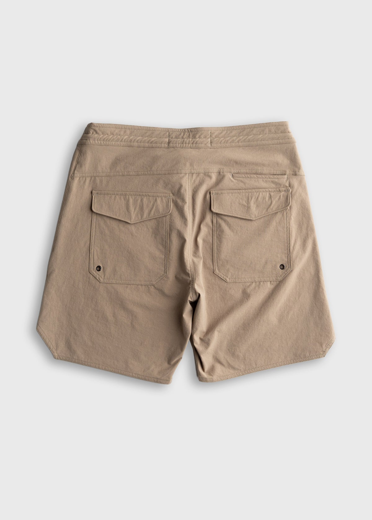 Beige shorts with dual back pockets on a plain background, showcasing casual style and practical design.