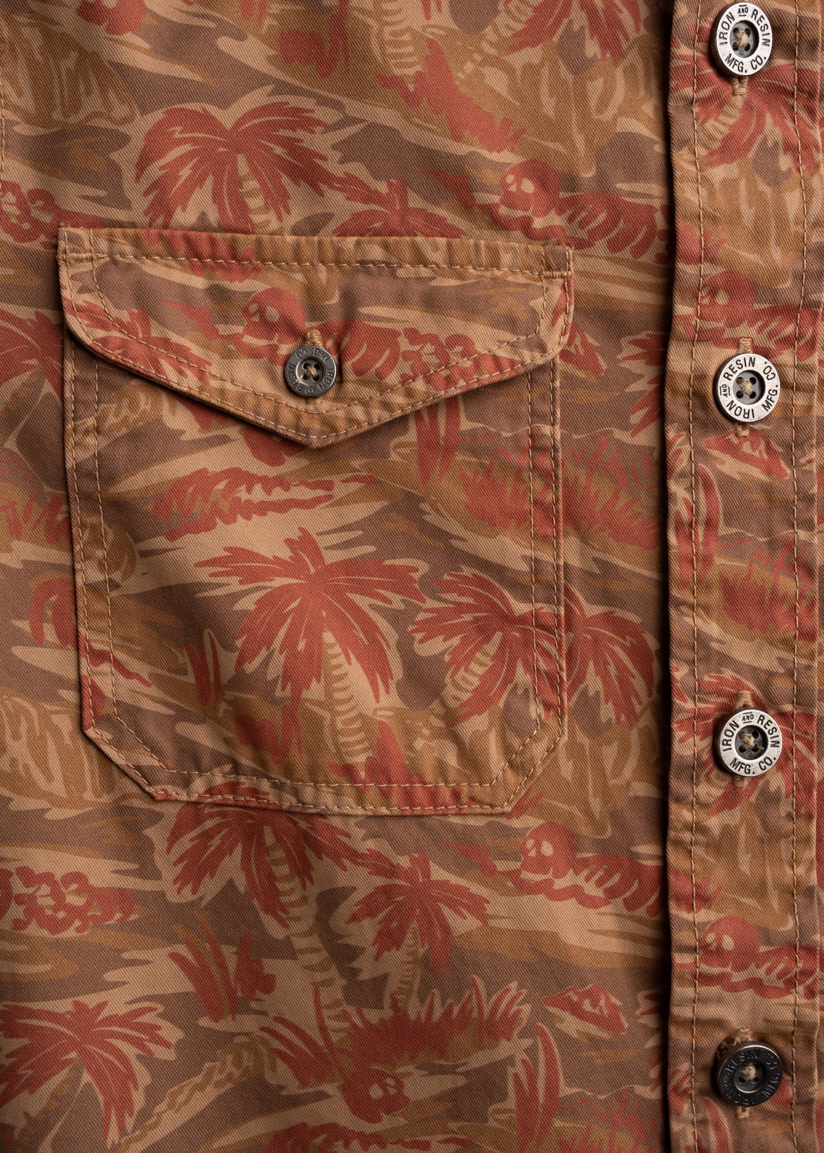 Close up of chest pocket on twill button up, showcasing custom buttons, stitching and utility design