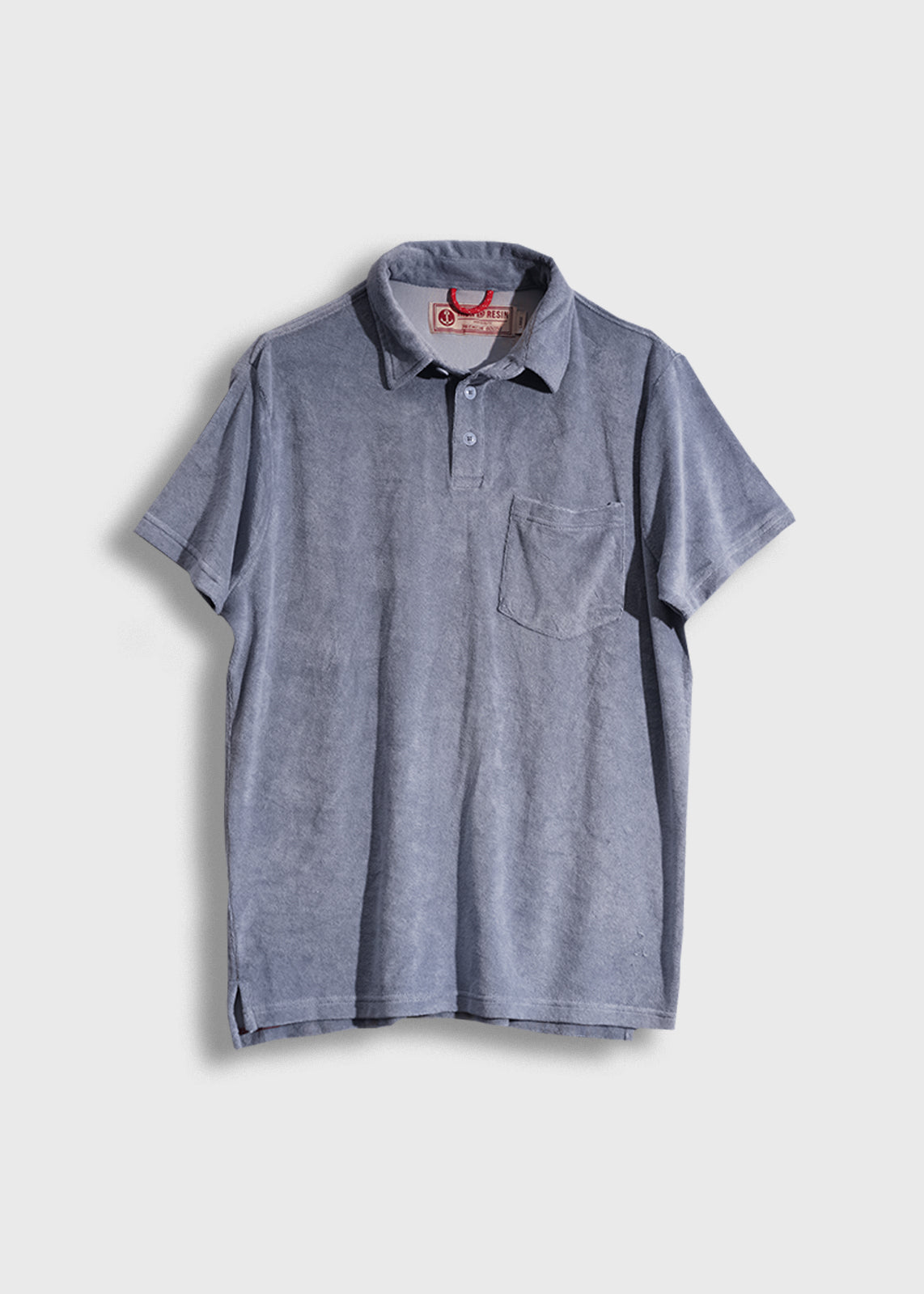 Gray polo shirt with a front pocket, short sleeves, and a collar, displayed against a plain background.