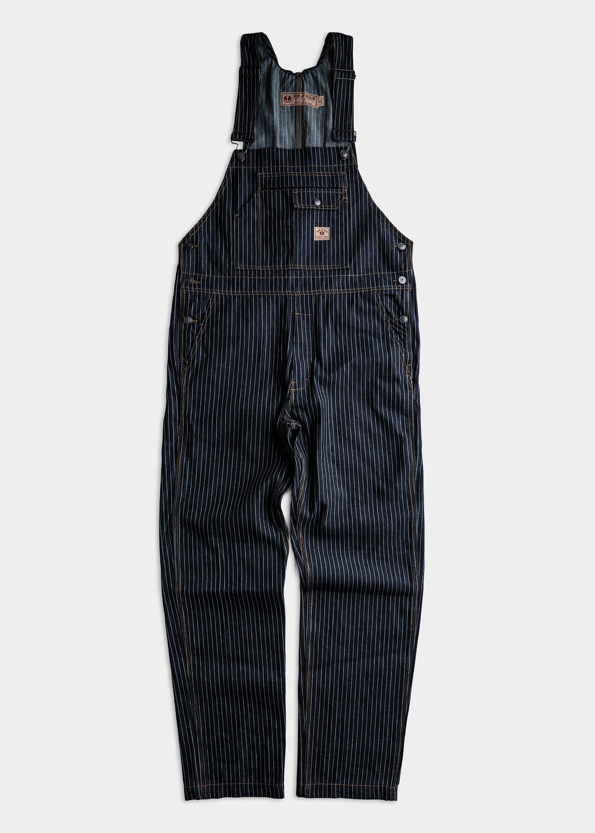 Dark blue pinstripe denim overalls with adjustable straps, front pocket, and button details, laid flat on a light background.