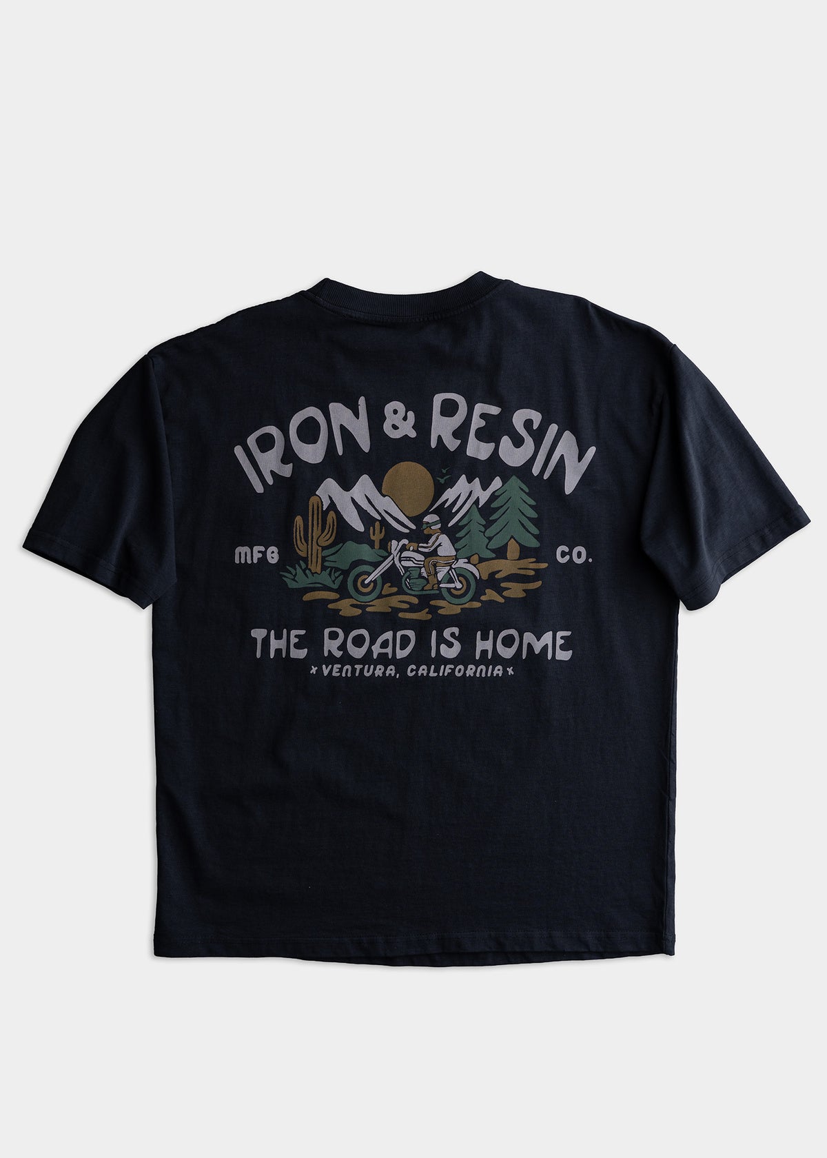 Black T-shirt with "Iron & Resin" logo, mountain, and motorcycle graphic. Text reads "The Road is Home, Ventura, California.